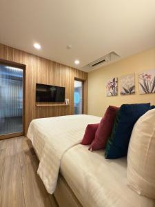 a bedroom with a large bed and a flat screen tv at Mybed Chonburi in Ban Nong Tako