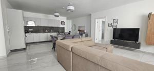 a living room with a couch and a tv and a kitchen at Central Apartment Sliema John in Sliema