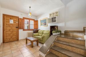 ein Wohnzimmer mit einer Treppe und einer Couch in der Unterkunft La Era de Alcántara in Cónchar