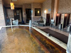 a lobby with a pool of water in the floor at Dormy Inn Akita in Akita
