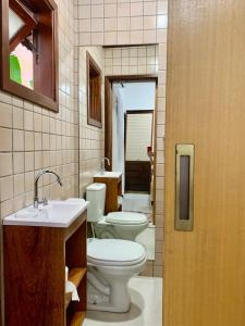 a bathroom with two toilets and a sink at Pretty house with pool and amazing garden in São Sebastião