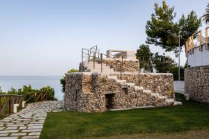 a stone building with stairs on top of it at AH Premium Baia dei Faraglioni in Mattinata