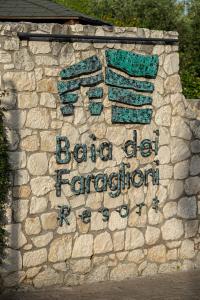 a sign on a stone wall that says baja die propagation at AH Premium Baia dei Faraglioni in Mattinata