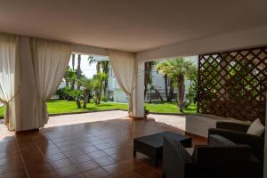 a living room with a view of a yard at AH Premium Baia dei Faraglioni in Mattinata