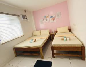 two twin beds in a room with a window at J Hotel in Roxas City