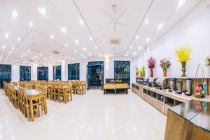 a banquet hall with tables and chairs and windows at SEN BIỂN HOTEL - FLC Sầm Sơn in Sầm Sơn +52 photos