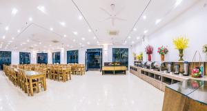 a banquet hall with tables and chairs and windows at SEN BIỂN HOTEL - FLC Sầm Sơn in Sầm Sơn +38 photos