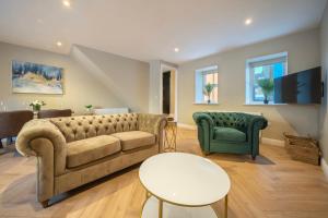 a living room with a couch and two chairs at Kinsale Holiday Homes No1 Newmans Mall in Kinsale