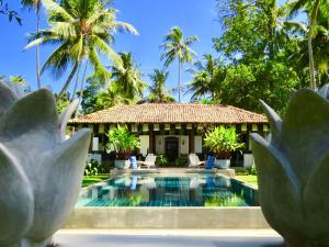 a villa with a swimming pool and palm trees at Samaragiri in Talpe +38 photos