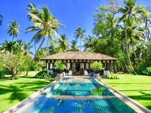 a villa with a swimming pool and a resort at Samaragiri in Talpe