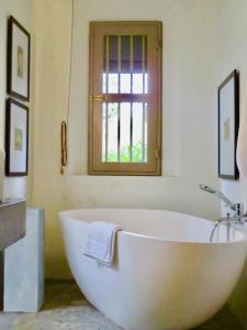 a white bath tub in a bathroom with a window at Samaragiri in Talpe