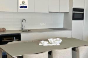 a kitchen with a table with two bowls on it at Sea View 1 BR Flat With Pool - Ideal For Couples & Families By SlowayStay Holiday Apartment & Short Term Rental Oostende in Ostend