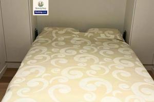 a bed in a bedroom with a bedspread on it at Sea View 1 BR Flat With Pool - Ideal For Couples & Families By SlowayStay Holiday Apartment & Short Term Rental Oostende in Ostend +7 photos