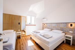 a bedroom with two beds and a window at Resort Trcol in Novalja