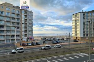 a parking lot with cars parked next to a building at Sea View 1 BR Flat With Pool - Ideal For Couples & Families By SlowayStay Holiday Apartment & Short Term Rental Oostende in Ostend