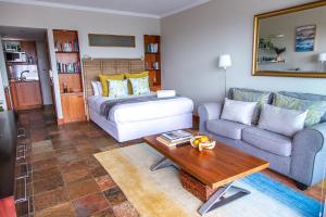 a living room with a couch and a table at Clifton Beachfront Studio-Sea Views & Walk To Beach in Cape Town