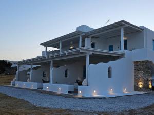 a white house with lights on the side of it at Jemphasis-New Apartments Mykonos in Agios Ioannis Mykonos