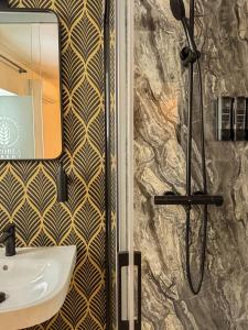 łazienka z prysznicem, umywalką i lustrem w obiekcie Hostal Boutique Cazorla Bakery w mieście Cazorla