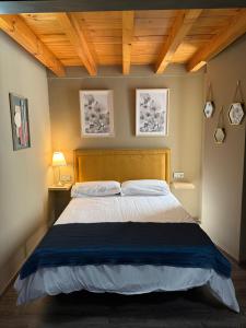 una camera da letto con un letto grande con testiera in legno di De Mamá a Molinaseca