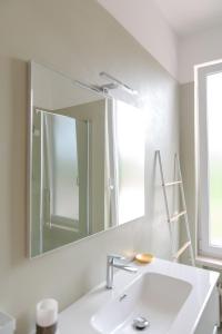 カステルヌオーヴォ・デル・ガルダにあるVilla Carini with 3000 mq garden & heated poolの白い洗面台と鏡のあるバスルーム