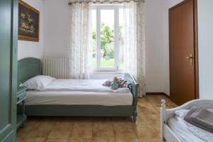 カステルヌオーヴォ・デル・ガルダにあるVilla Carini with 3000 mq garden & heated poolの小さな子供が寝室のベッドに寝そべって +24枚の写真