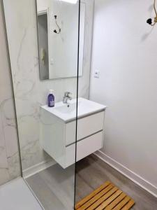 a white bathroom with a sink and a shower at Poterne- Logement raffiné avec jardin in Aubeterre-sur-Dronne +43 photos