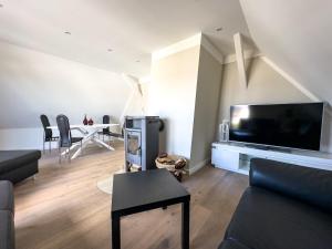 a living room with a large flat screen tv at Stilvolle Dachgeschosswohnung am Teutoburger Wald in Steinhagen