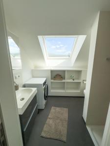 a bathroom with a skylight and a sink at Stilvolle Dachgeschosswohnung am Teutoburger Wald in Steinhagen