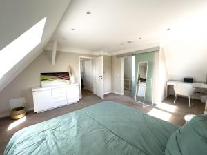 a bedroom with a large bed and a desk at Stilvolle Dachgeschosswohnung am Teutoburger Wald in Steinhagen