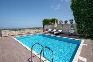 basen z 2 leżakami obok w obiekcie Roupes Villa III, Family villa, Fantastic views, Private pool w mieście Roúpai