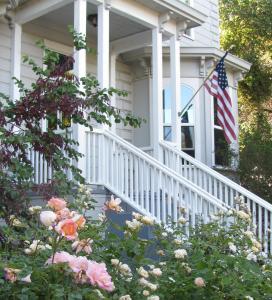 una casa con una bandera americana en el porche delantero en Yosemite Rose Bed and Breakfast en Groveland