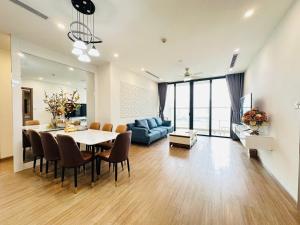 a living room with a table and a blue couch at Vinhomes Sky Lake Phạm Hùng View Keangnam in Hanoi