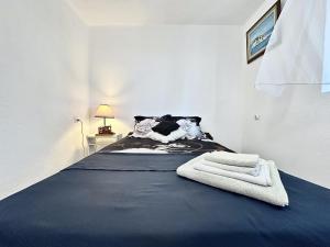 a bedroom with a bed with two towels on it at Veles House in Herceg-Novi