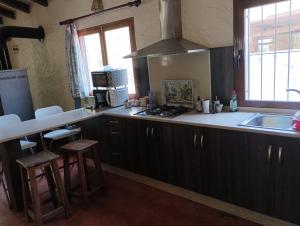a kitchen with a sink and a stove top oven at Dos casas rurales con piscina in Caravaca de la Cruz