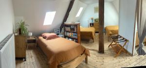 een slaapkamer met 2 bedden en een boekenplank bij La Parenthèse in Mortagne-au-Perche