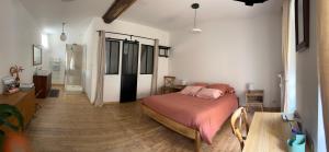 een slaapkamer met een bed met een roze deken bij La Parenthèse in Mortagne-au-Perche +7 foto's