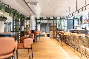 a bar in a restaurant with chairs and tables at Scandic Simonkenttä in Helsinki