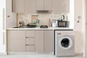 a kitchen with a washing machine and a sink at Cosy studio Free Parking Free unlimited drinkable water Near Downtown in Dubai