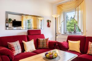 a living room with a red couch and a table at Ferienwohnung Tannenblick 6-1 in Oberhof