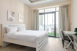 a white bedroom with a large bed and a desk at Cosy studio Free Parking Free unlimited drinkable water Near Downtown in Dubai +61 photos