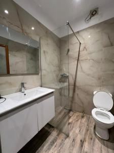 a bathroom with a toilet and a sink and a shower at Atlantid Hospitality Hotel in Qeparo +58 photos