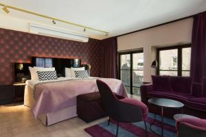 a bedroom with a large bed with purple walls at Haymarket by Scandic in Stockholm +135 photos