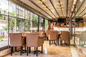 a restaurant with tables and chairs and large windows at Berrak Su Hotel in Antalya