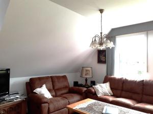 ein Wohnzimmer mit Sofa und Tisch in der Unterkunft De Luxe - Ferienwohnung im Landhaus am See - Die Nr 1 mit 5 DTV zertifizierten Sternen in Malente