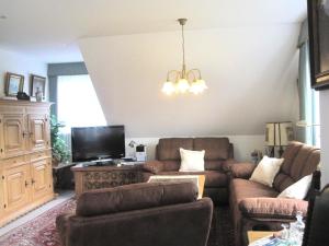 ein Wohnzimmer mit Sofa und Fernseher in der Unterkunft De Luxe - Ferienwohnung im Landhaus am See - Die Nr 1 mit 5 DTV zertifizierten Sternen in Malente
