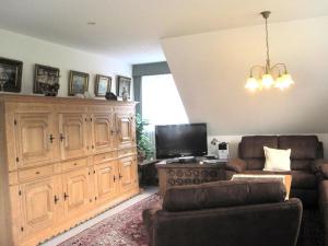 ein Wohnzimmer mit Sofa und Fernseher in der Unterkunft De Luxe - Ferienwohnung im Landhaus am See - Die Nr 1 mit 5 DTV zertifizierten Sternen in Malente + 13 Fotos