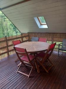 a wooden table and chairs on a deck at Le chalet a la ferme in Massat