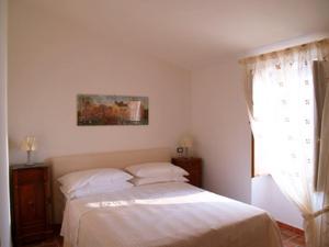 un letto in una camera con finestra e copriletto di B&B La Casa Rossa a Paola