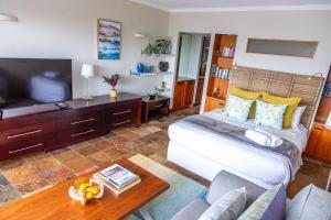 a bedroom with a large bed and a television at Clifton Studio - Seaviews & Walk To The Beach, Sea Point & Camps Bay in Cape Town