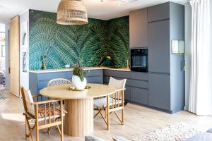 a kitchen with a table with chairs and a plant on the wall at MEREKARP Living in Tallinn